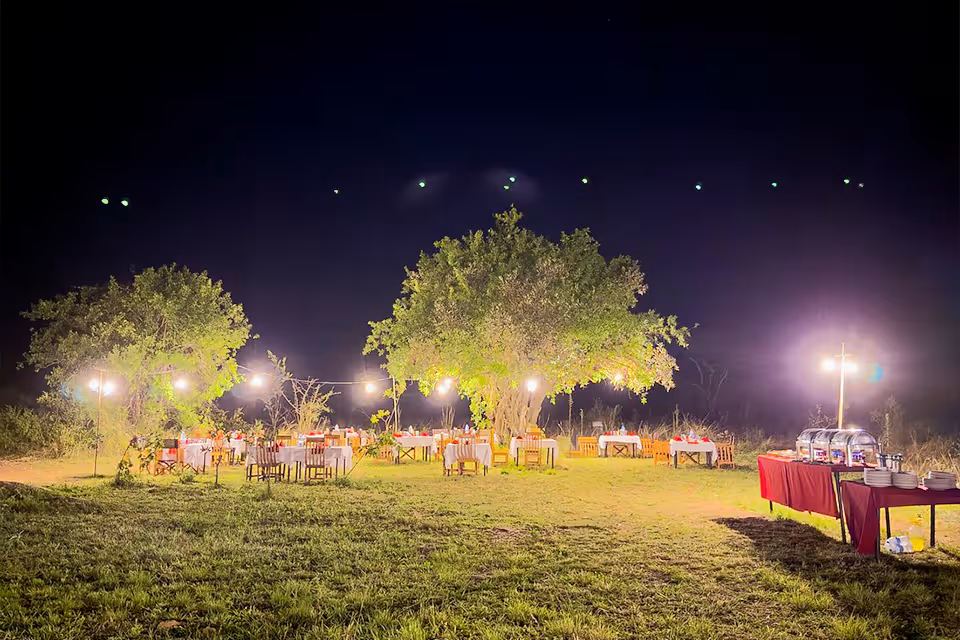 A candlelit dinner table under the open sky