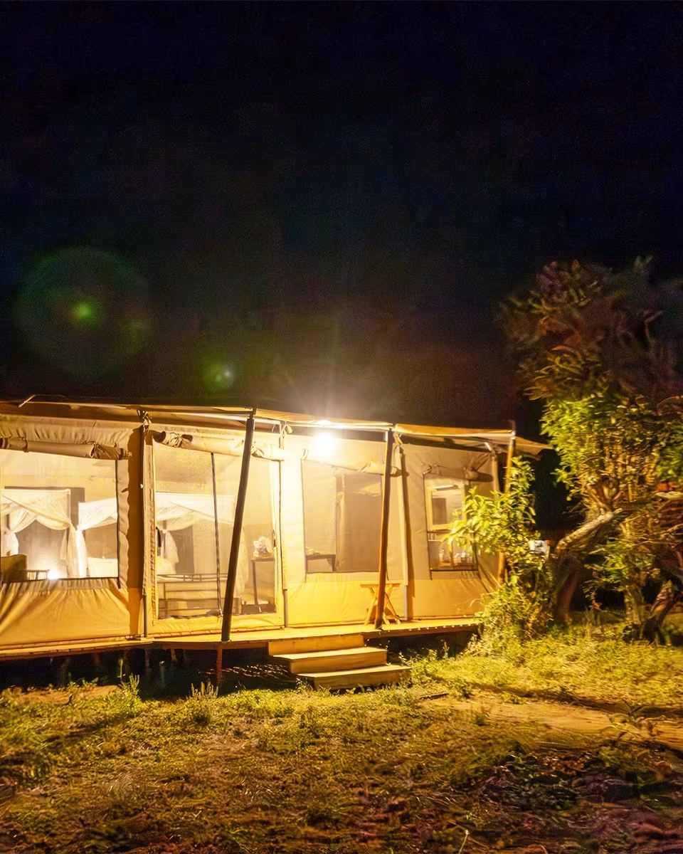 A tented suite at dusk with the lanterns lit